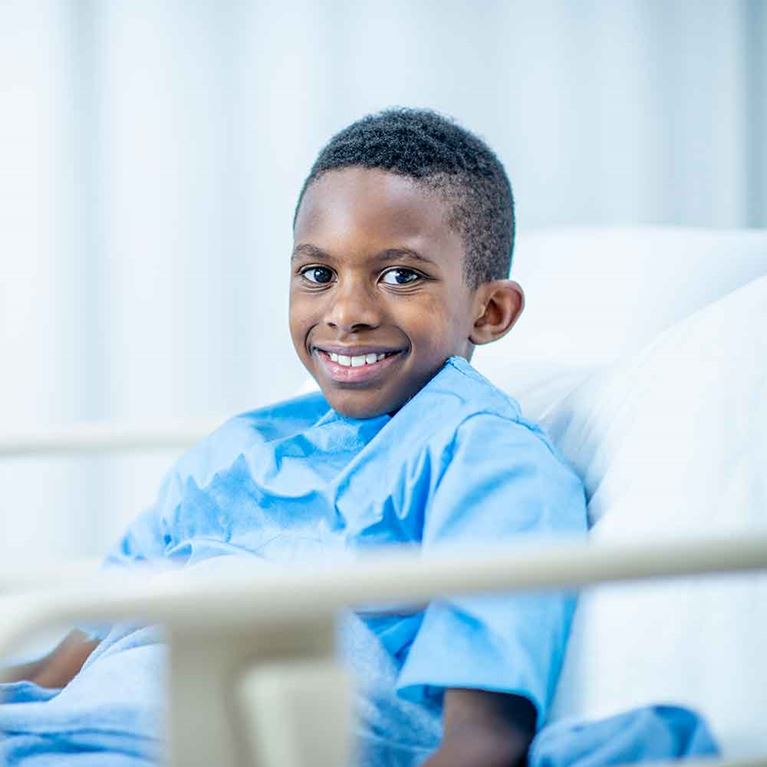  Smiling child in hospital bed.