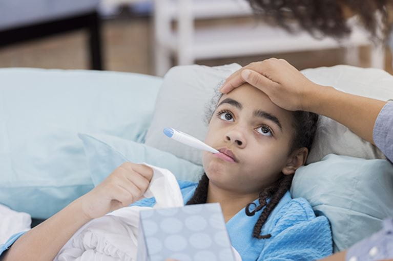 Girl having temperature checked