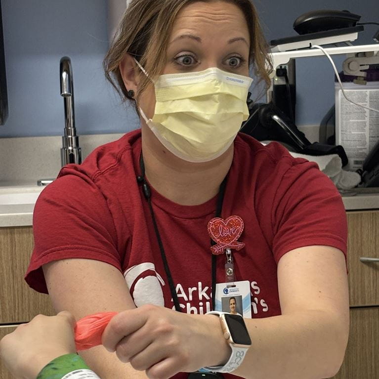 Occupational therapist wearing mask and red shirt. 
