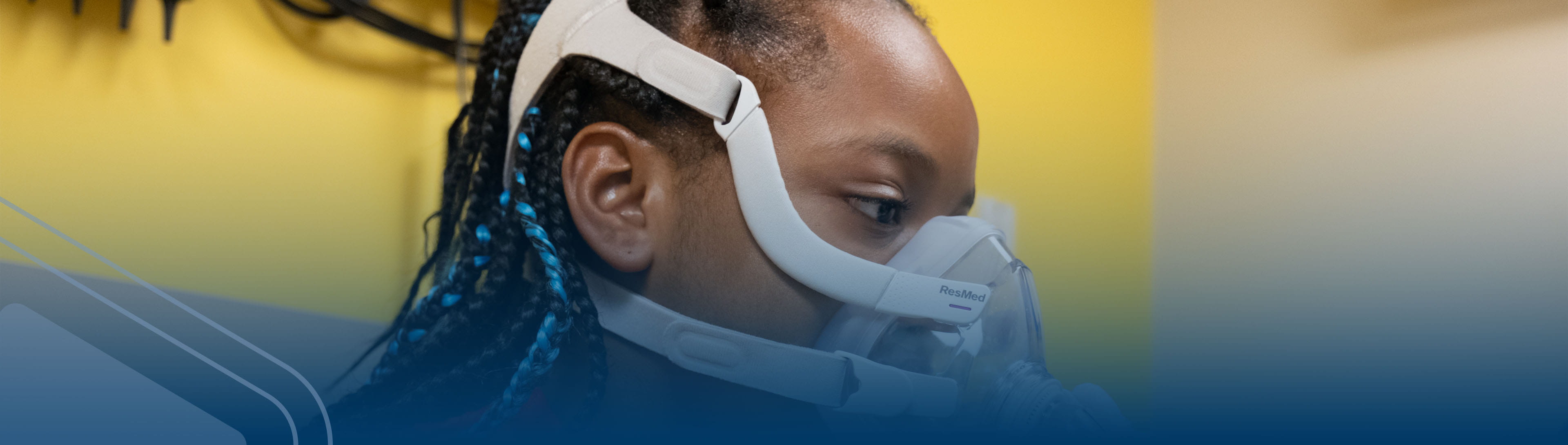 Teen boy wearing CPAP mask in clinic.